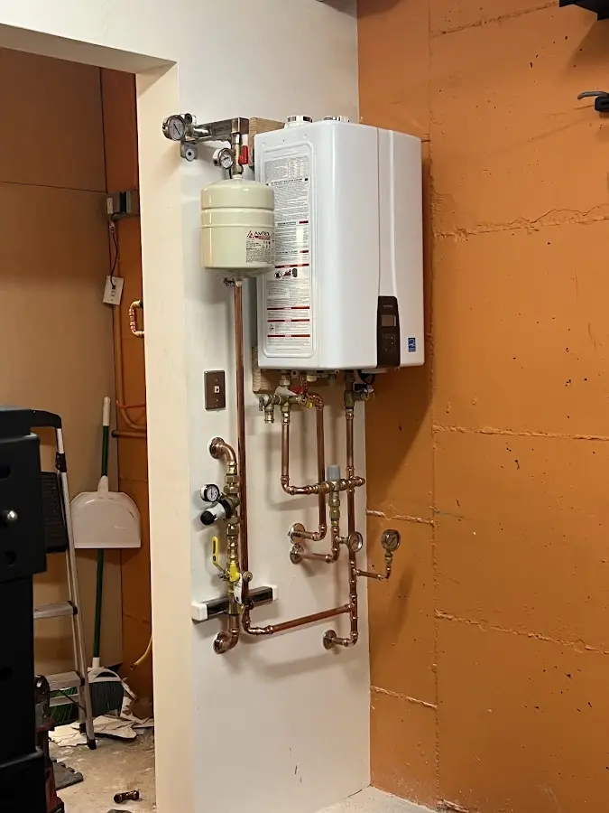 Plumbing technician inspecting water heater connections in Bridgetown